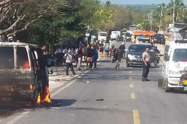 Anggota Polres Kupang mengatur arus lalu lintas saat mikrolet Syalom terbakar di jalan Timor Raya, Senin (15/8/2022). 