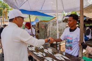 Cagub NTT, Ansy Lema menyapa salah satu pendukung yang sementara menjual ikan hasil tangkapan nelayan.